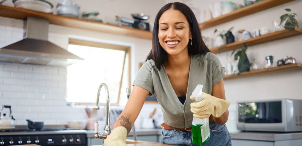 a woman cleaning the kitchen top surface as part of spring cleaning