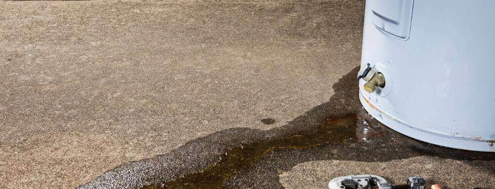 a water heater leaking with tools on the side
